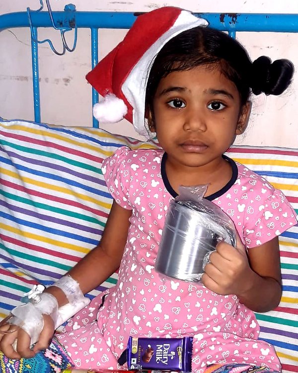 Keerthi wearing a Santa hat in hospital